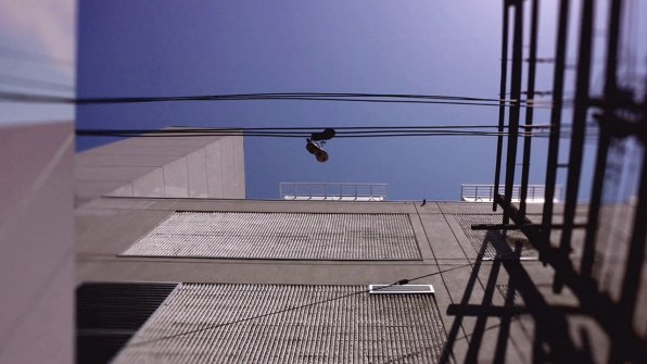 Premium Photo | Sneakers canvas shoes hanging on power line fog on city  street boots on wires