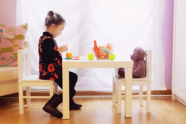 little girl make a tea party with her plush teddy bear