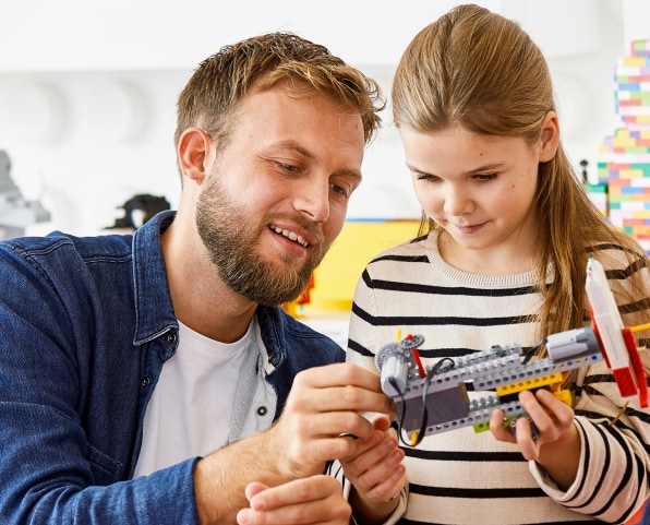 girl is playing with Lego with her father